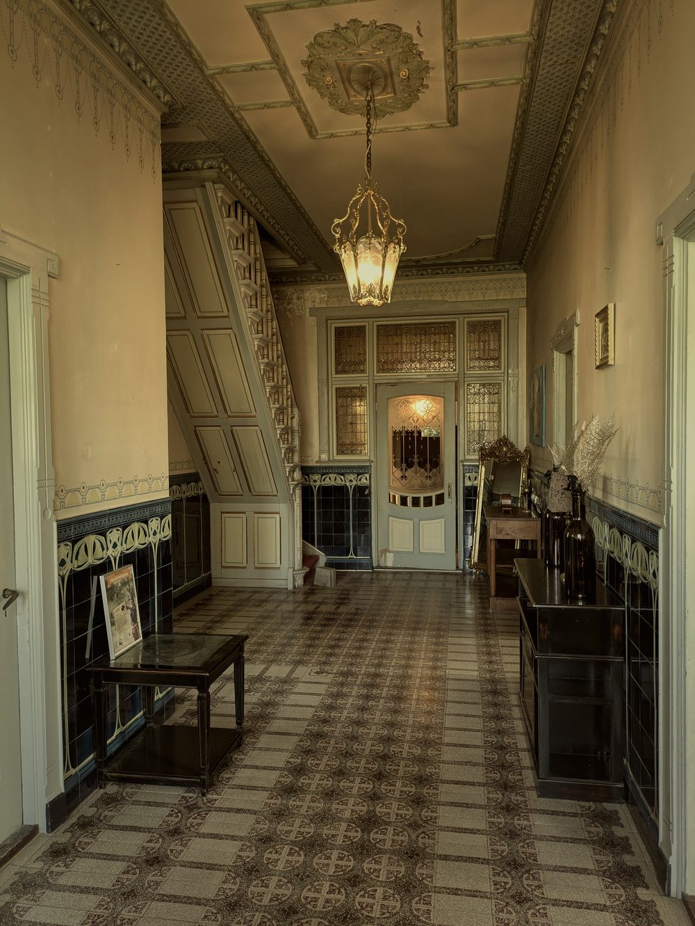 Historische hal van Restaurant Veldzicht Westerlee — originele tegels, glas-in-lood en jugendstil plafond uit 1910
